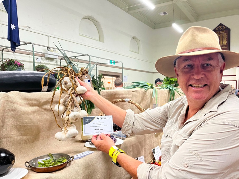 Michael Taylor holding an award-winning bunch of garlic at the Berry Show